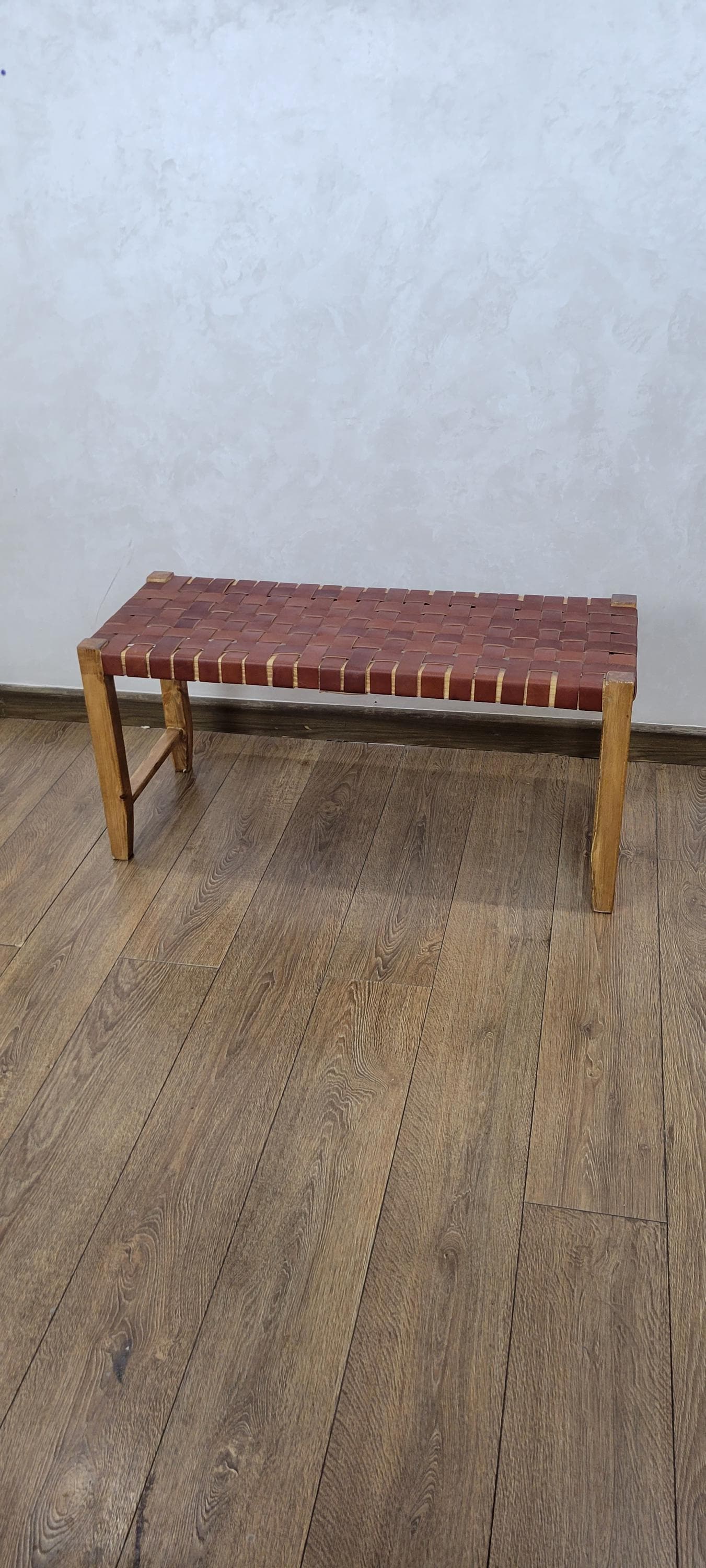 Woven Leather Bench — side view of artisan stitching