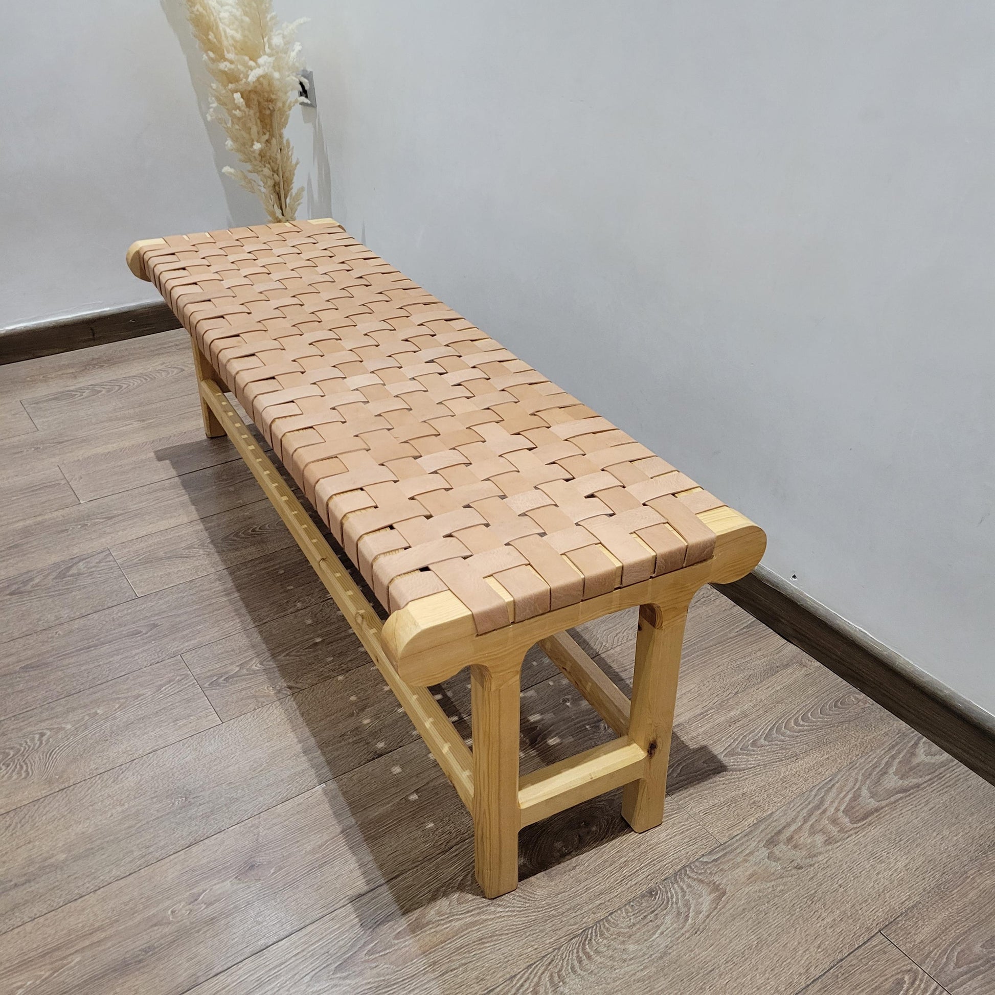 Woven Leather Bench — side view of artisan stitching