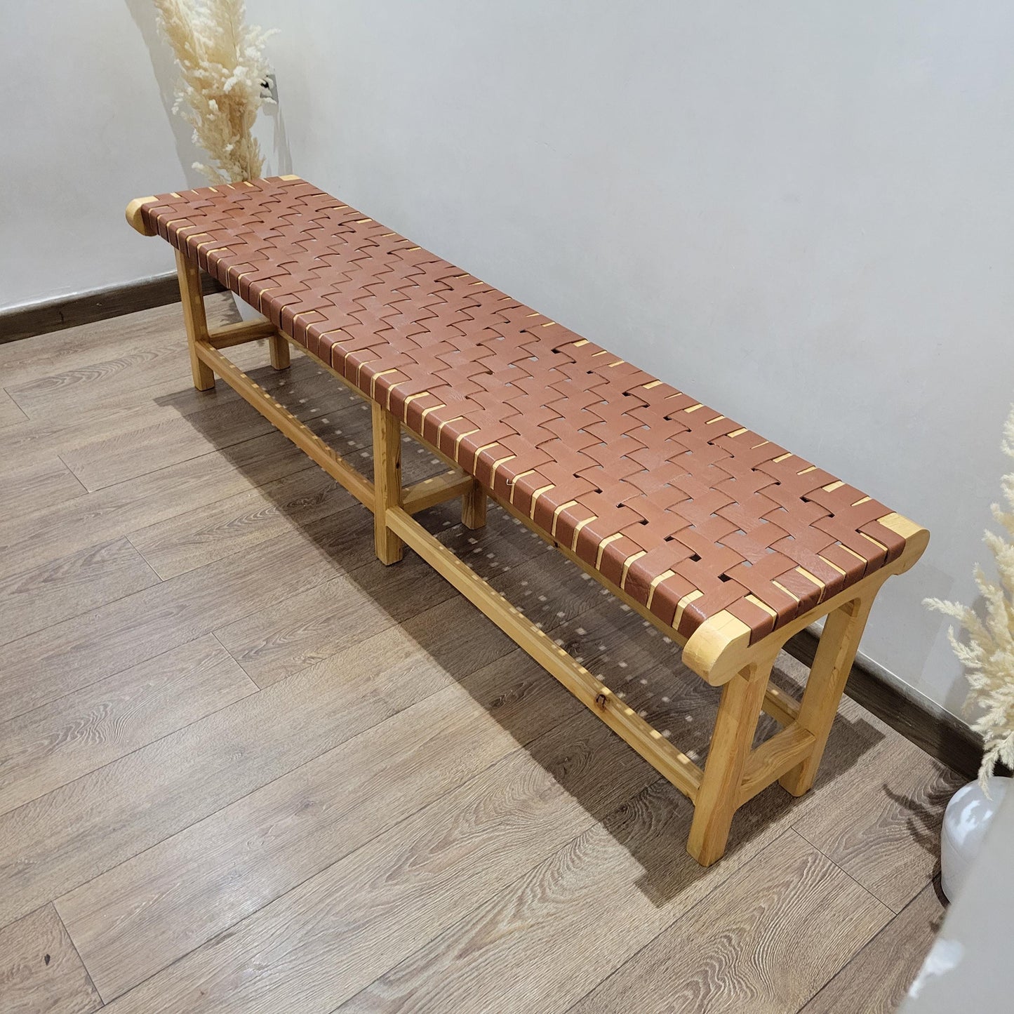 Woven Leather Bench — side view of artisan stitching