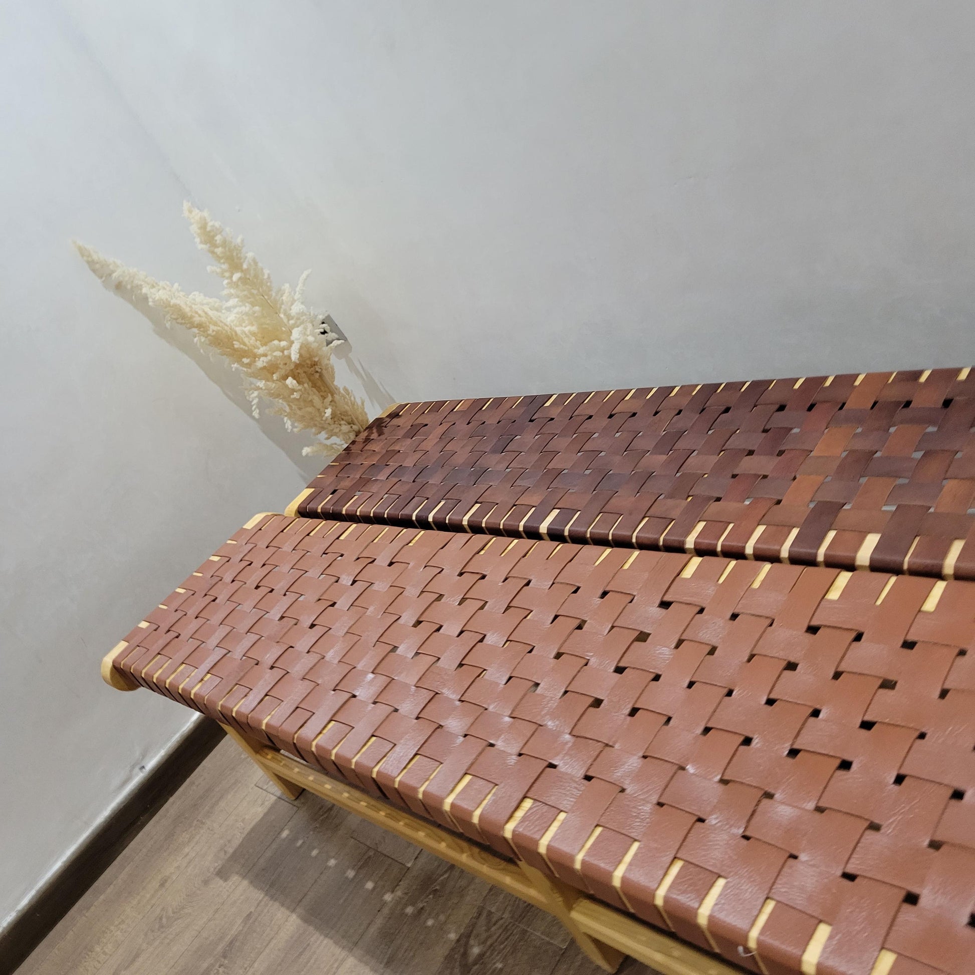 Woven Leather Bench — side view of artisan stitching