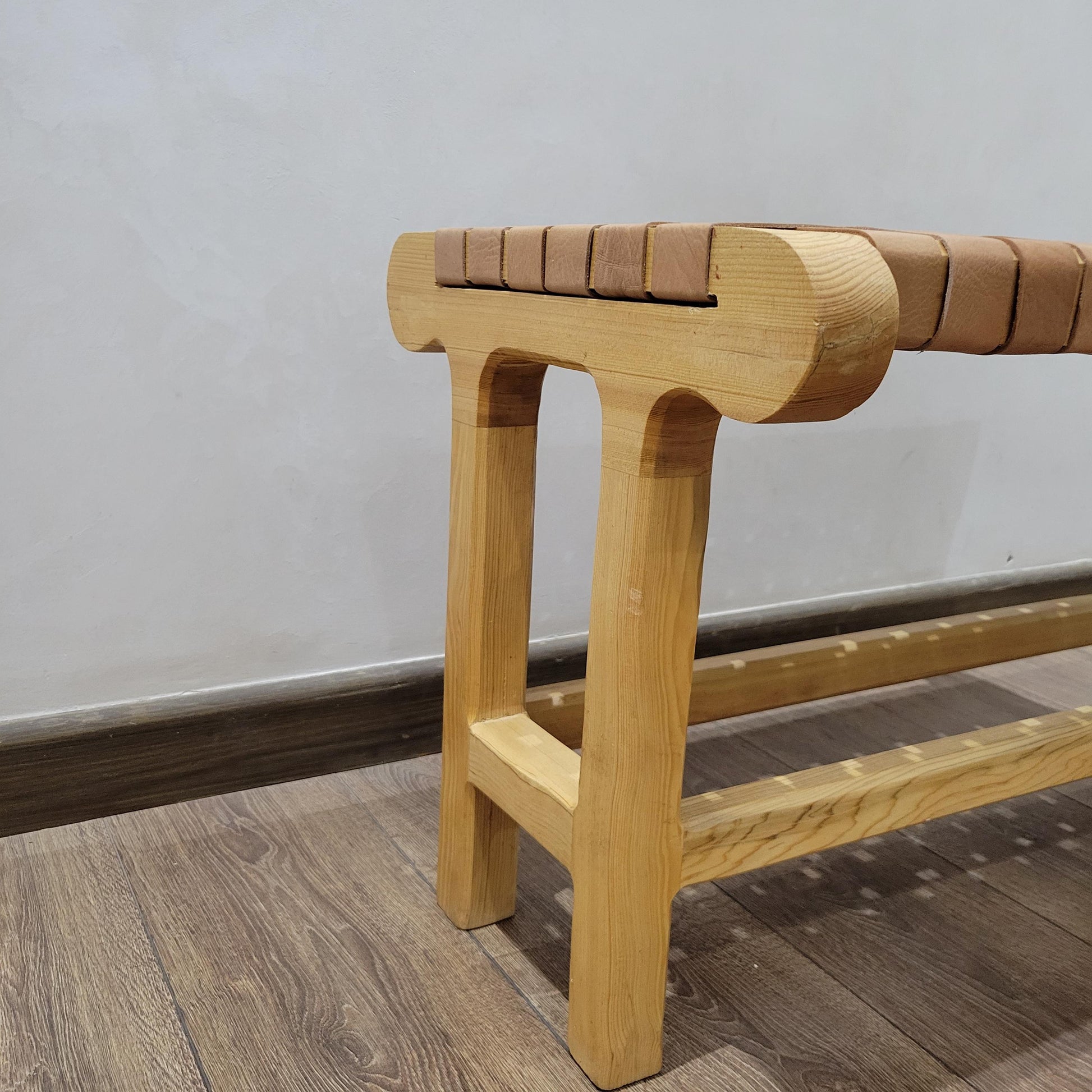 Woven Leather Bench — side view of artisan stitching